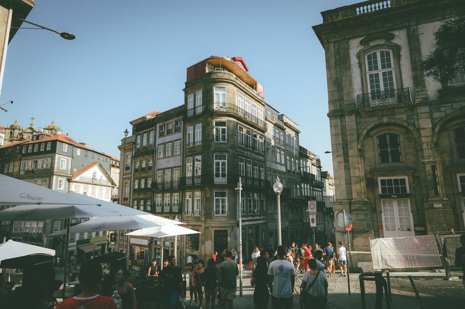 Street scene with historic European architecture and people exploring the area on a sunny day.